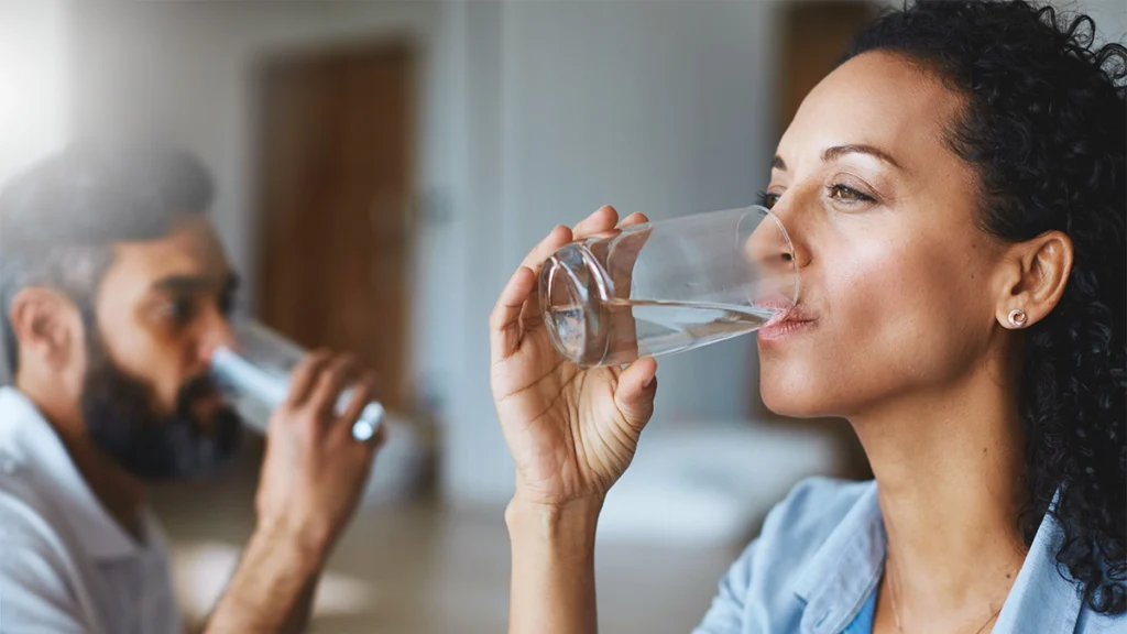 Couple drinking water to stay hydrated at home