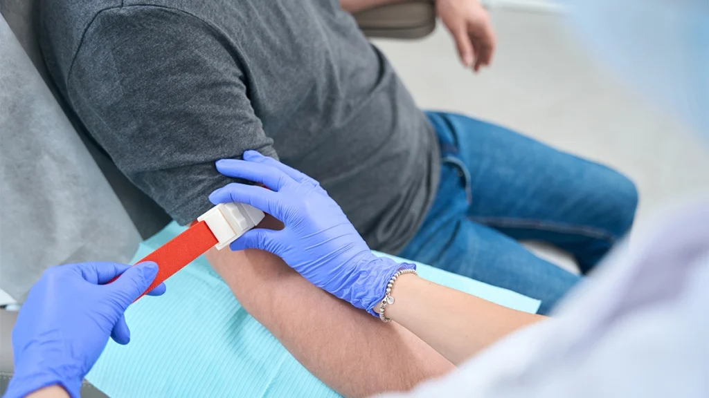 Medical professional applying a tourniquet on patient